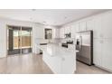 Open concept kitchen with island, stainless appliances, and easy access to the outdoor area at 11611 W Green Dr, Youngtown, AZ 85363