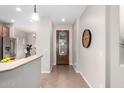 Bright entryway with tile floors, designer clock and decorative front door at 1414 W Alder Rd, Queen Creek, AZ 85140