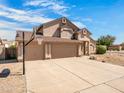Inviting two-story home featuring a spacious driveway and a basketball hoop for outdoor fun at 14317 N 78Th Dr, Peoria, AZ 85381