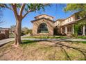 Beautiful home with a unique arched window and well-maintained lawn, creating an inviting curb appeal at 15239 W Alexandria Way, Surprise, AZ 85379