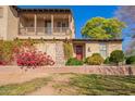 Charming two-story home with a cozy balcony, stone accents, and a welcoming red front door at 15239 W Alexandria Way, Surprise, AZ 85379