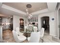 Elegant dining area featuring a glass table, white chairs, and sophisticated lighting at 15802 N 71St St # 501, Scottsdale, AZ 85254