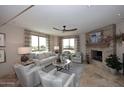 Cozy living room features a stone fireplace, tile flooring, and bright windows with natural light at 15802 N 71St St # 501, Scottsdale, AZ 85254