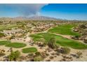 Stunning aerial view of a golf course community with mountain views and lush green fairways at 18068 W Narramore Rd, Goodyear, AZ 85338
