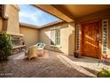 Cozy outdoor patio featuring a fireplace, comfortable seating, and a charming tiled floor at 18068 W Narramore Rd, Goodyear, AZ 85338