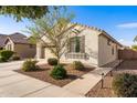 Beige stucco home with a well-maintained landscape and hardscaped walkway leading to the entrance at 21244 E Creekside Dr, Queen Creek, AZ 85142
