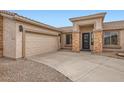 Garage and entrance of a home with stone pillars and desert landscaping at 22181 N 78Th St, Scottsdale, AZ 85255