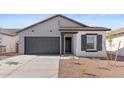 Beautifully designed single-Gathering home with gray siding, black accents, and a well-maintained front yard at 23435 W Albeniz Pl, Buckeye, AZ 85326