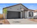 Inviting single-Gathering home with a dark garage door, gray vertical siding and contrasting black trim on a sunny day at 23435 W Albeniz Pl, Buckeye, AZ 85326