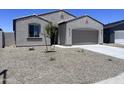 Charming single-story home featuring a neutral stucco exterior, desert landscaping and a two-car garage at 24080 W Bowker St, Buckeye, AZ 85326