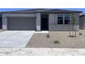 Charming home showcasing a paved driveway, gray garage door, and neutral colored facade at 24088 W Bowker St, Buckeye, AZ 85326
