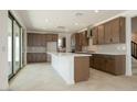 Modern kitchen features a large island, ample storage, stainless appliances, and sliding doors to the backyard at 40101 N Alameda Dr, San Tan Valley, AZ 85140