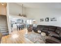 Bright living room featuring wood floors, a vaulted ceiling, and an open layout with gray kitchen cabinets at 4343 E Contessa St, Mesa, AZ 85205