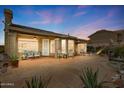 Backyard patio with covered lounge area, desert plants, and stone details at 4903 S Desert Willow Dr, Gold Canyon, AZ 85118
