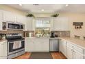 Well-lit kitchen featuring stainless steel appliances and white cabinetry at 5206 N 16Th Dr, Phoenix, AZ 85015