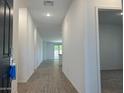 Bright hallway features wood-look flooring and fresh neutral paint leading to the main living area at 5519 S 240Th Ln, Buckeye, AZ 85326