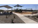 Community playground featuring a variety of play structures including a slide, swings, and picnic tables at 5519 S 240Th Ln, Buckeye, AZ 85326