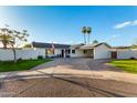Charming single-story home with a circular driveway, palm trees and well maintained lawn at 6718 N 19Th Pl, Phoenix, AZ 85016