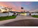 Charming single-story home with a circular driveway, palm trees and well maintained lawn at 6718 N 19Th Pl, Phoenix, AZ 85016