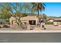 Attractive desert home boasts a classic Southwestern design, mature trees, and desert landscaping under a clear blue sky at 902 W Moon Valley Dr, Phoenix, AZ 85023