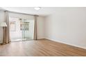 Bright living room with wood floors, curtains, sliding door to balcony and neutral tones at 1021 S Greenfield Rd # 1106, Mesa, AZ 85206