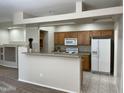 Open kitchen with breakfast bar, white appliances, and tile flooring at 11500 E Cochise Dr # 1063, Scottsdale, AZ 85259