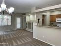 Open concept living and kitchen area with modern chandelier, and neutral walls at 11500 E Cochise Dr # 1063, Scottsdale, AZ 85259