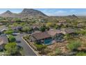 Panoramic aerial view of a desert community featuring tile-roofed homes and private pools set against a backdrop of scenic mountains at 13896 E Kalil Dr, Scottsdale, AZ 85259
