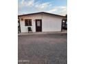 Exterior view of a building featuring a gravel yard and a white exterior, highlighted by brown trim around windows and doors at 1618 S Cedar Dr, Apache Junction, AZ 85120