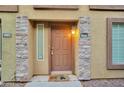 Close-up of a unit entrance with decorative stone accents and a charming welcome mat at 1920 E Bell Rd # 1006, Phoenix, AZ 85022