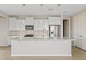 Bright kitchen features white cabinetry, stainless steel appliances, stone backsplash and an oversized island at 25424 S 224Th Pl, Queen Creek, AZ 85142