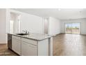 Open-concept kitchen features a granite countertop island, stainless steel appliances, and flows into a spacious living area at 25431 W Graham Trl, Buckeye, AZ 85326