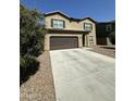 Two-story home with low maintenance landscaping and large driveway surrounded by a small tree at 36992 W Capri Ave, Maricopa, AZ 85138