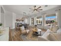 Bright open-concept living room with wood floors, fireplace, modern furniture, and large windows showcasing the backyard at 3953 E Lafayette Ave, Gilbert, AZ 85298