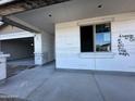 New construction featuring a two-car garage and covered porch area with window framing visible at 5631 W Summerside Rd, Laveen, AZ 85339