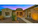 Inviting home exterior with a circular entryway, desert landscaping, and warm lighting at 5632 S Four Peaks Pl, Chandler, AZ 85249