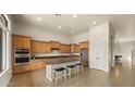 Bright kitchen featuring a central island, granite countertops, stainless steel appliances and light wood cabinetry at 5632 S Four Peaks Pl, Chandler, AZ 85249