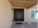Elegant double front doors under a covered porch, complemented by desert landscaping and a side window at 6242 E Hearn Rd, Scottsdale, AZ 85254