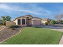 Well-kept single-story home showcases desert landscaping, a two-car garage, and a tidy front lawn at 6439 W Adobe Dr, Glendale, AZ 85308