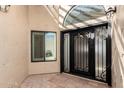 Elegant entryway with an iron door, transom window and neutral tile flooring at 7955 E Chaparral Rd # 120, Scottsdale, AZ 85250