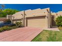 Desert home with stucco walls, a tile driveway, and lush desert landscaping at 7955 E Chaparral Rd # 120, Scottsdale, AZ 85250