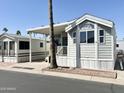 Exterior view of a charming light grey home with a covered parking and desert landscape at 903 S Mineshaft Dr, Apache Junction, AZ 85119