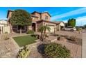 Well-maintained front yard featuring a paver driveway, artificial grass, mature trees, and easy access to the street at 10746 W Desert Elm Ln, Peoria, AZ 85383
