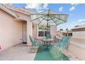 Inviting front porch with comfortable seating, a table, and a stylish striped umbrella at 1433 E Indian Wells Dr, Chandler, AZ 85249
