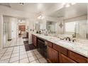 Spacious bathroom featuring double sinks, granite countertops, and large mirrors at 16292 N Naegel Dr, Surprise, AZ 85374