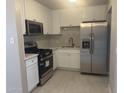 Modern kitchen features white cabinets, stainless steel appliances, and a stylish marble backsplash at 2010 N 38Th Ave, Phoenix, AZ 85009