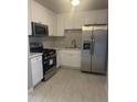 Bright kitchen boasts stainless steel appliances, white cabinetry and a marble-patterned backsplash at 2010 N 38Th Ave, Phoenix, AZ 85009