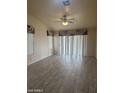 Spacious living room with wood-look tile flooring, ceiling fan, and bright natural light at 20625 N 104Th Ave, Peoria, AZ 85382