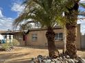 Single story home showcasing desert landscaping and mature palm trees at 2307 W Sierra St, Phoenix, AZ 85029