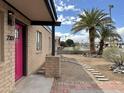 Charming house featuring a vibrant pink door, stone walkway and desert landscaping at 2307 W Sierra St, Phoenix, AZ 85029